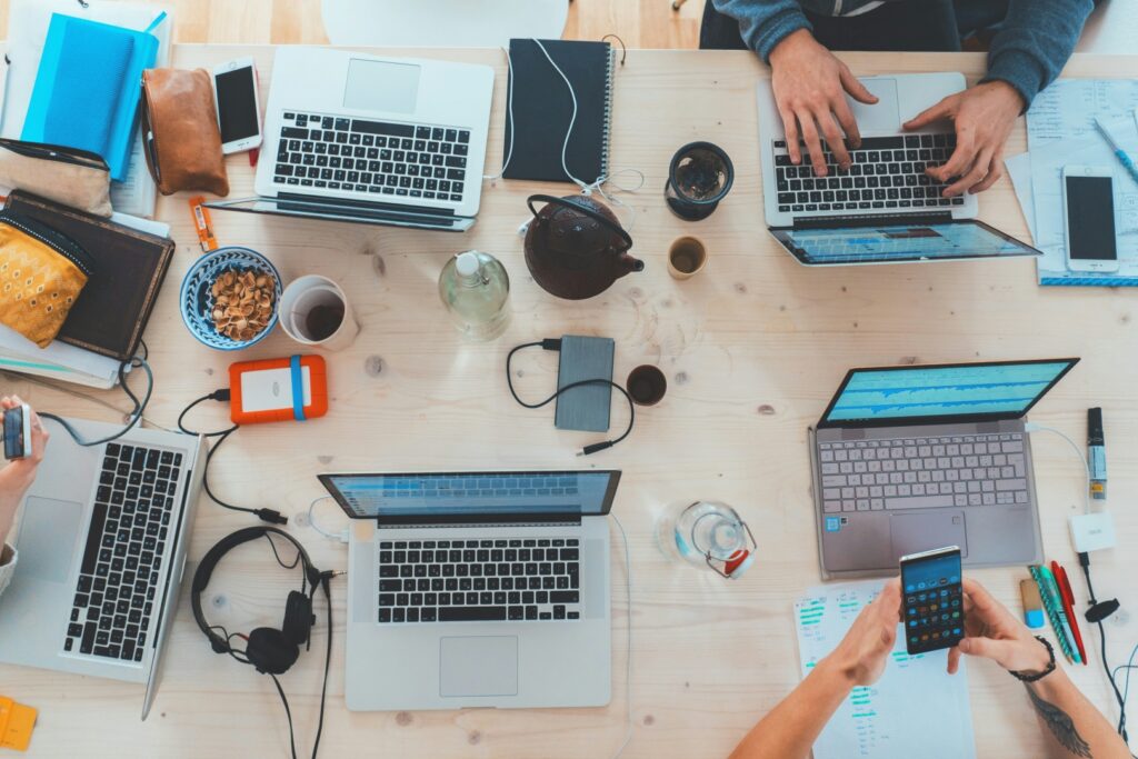 People sitting around a table with digital devices.