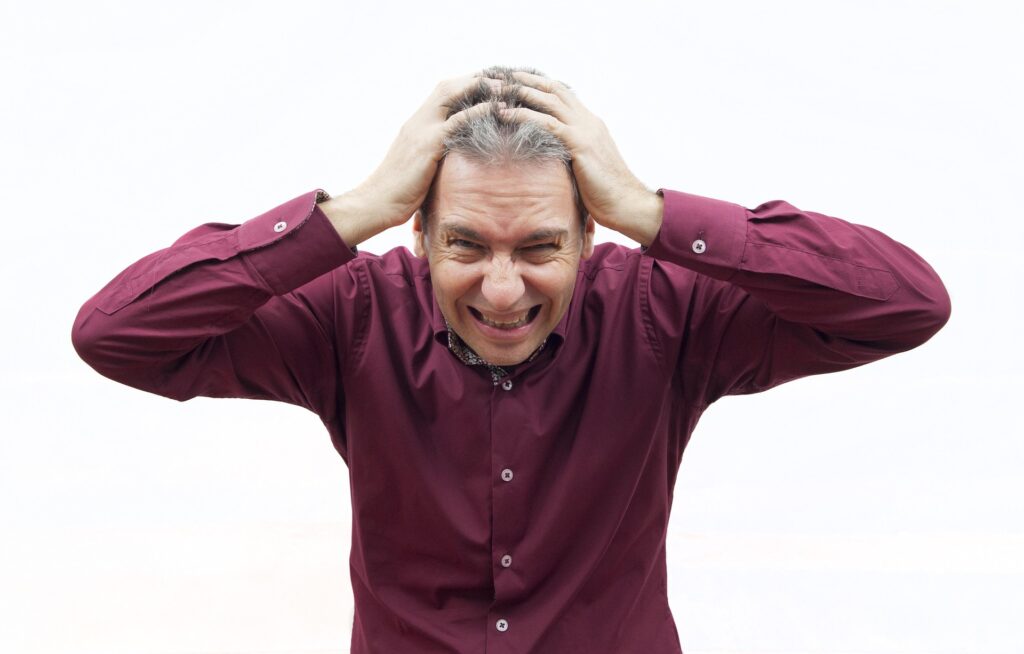 A stressed man holding his head